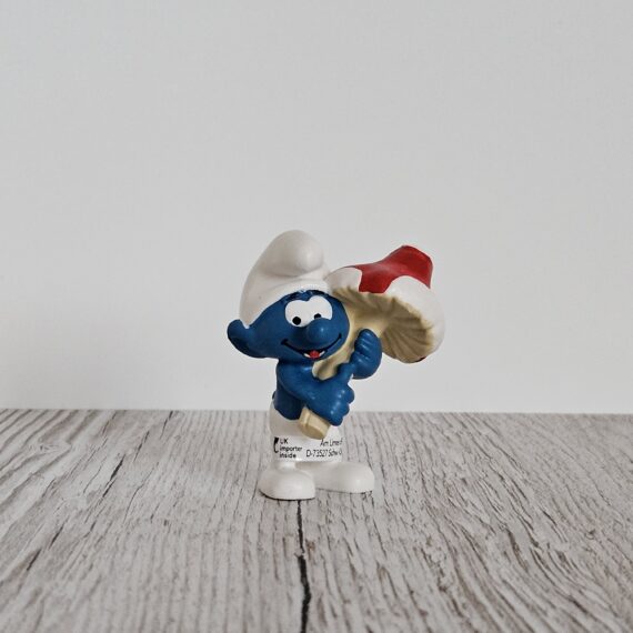 Schleich Figur namens Schlumpf mit Glückspilz der Produktwelt Die Schlümpfe. Die Figur hat die offizielle Schleichnummer 20819. Die Figur trägt das Copyrightjahr 2019 und wurde dann von Schleich offiziell lizenziert. Die Schleichfigur wird eingestuft als Regulär.