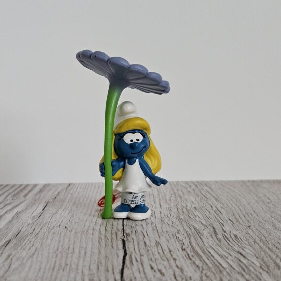 Schleich Figur namens Schlumpfine mit Blume der Produktwelt Die Schlümpfe. Die Figur hat die offizielle Schleichnummer 20828. Die Figur trägt das Copyrightjahr 2020 und wurde dann von Schleich offiziell lizenziert. Die Schleichfigur wird eingestuft als Regulär.