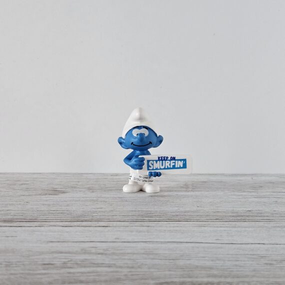 Schleich Figur namens Schlumpf Smurfin Schild der Produktwelt Die Schlümpfe. Die Figur hat die offizielle Schleichnummer 20843. Die Figur trägt das Copyrightjahr 2019 und wurde dann von Schleich offiziell lizenziert. Die Schleichfigur wird eingestuft als Regulär.